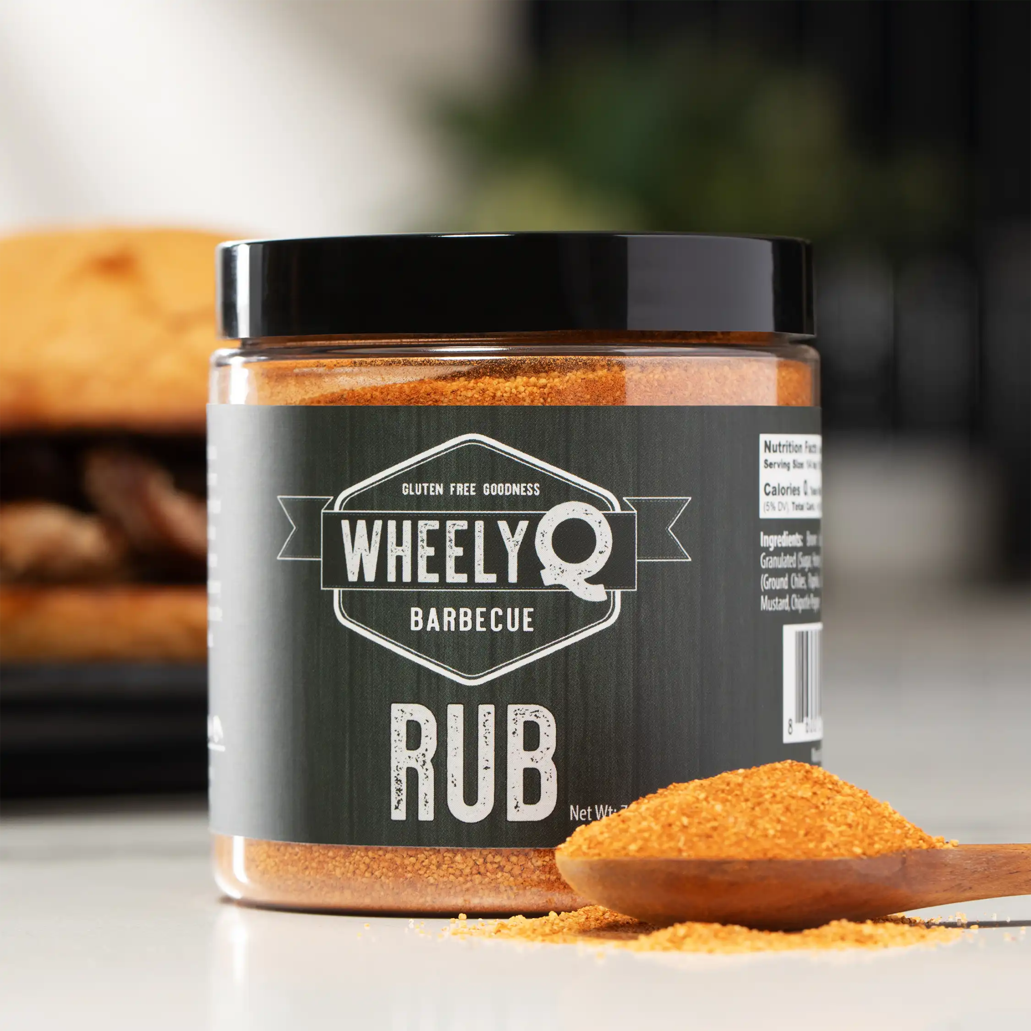 WheelyQ Barbecue All-Purpose Barbecue Rub with a spoonful of rub in a wooden spoon.