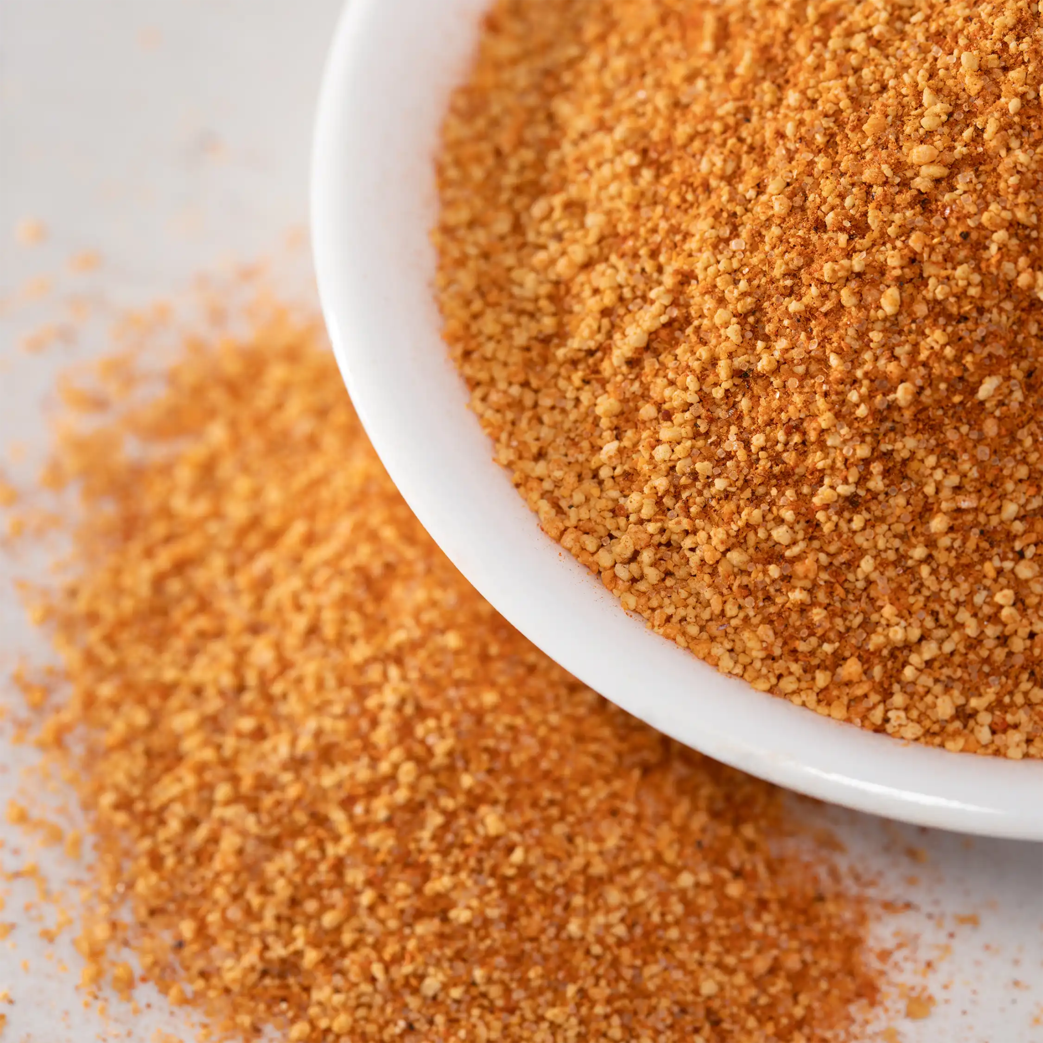 Close-up of WheelyQ Barbecue All-Purpose Barbecue Rub in a white bowl on a kitchen counter.